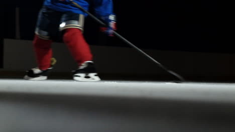 Close-up-of-the-puck-is-on-the-ice-and-in-slow-motion-hockey-player-pulls-up-and-the-snow-flies-into-the-camera-and-he-takes-the-puck-stick